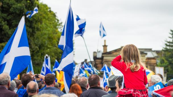 Child in crowd with Scottish flags